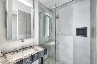 a bathroom with a glass shower and a sink at Nova Hotel Brooklyn in Brooklyn