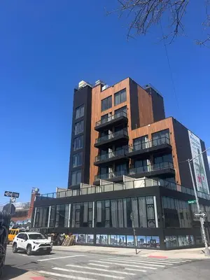 a tall building with a car parked in front of it at Nova Hotel Brooklyn in Brooklyn