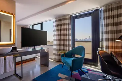 a hotel room with a television and a desk and chairs at Renaissance New York Harlem Hotel in New York