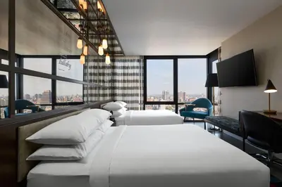 two beds in a hotel room with a view at Renaissance New York Harlem Hotel in New York