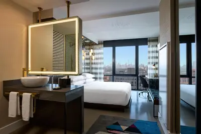 a hotel room with a bed and a mirror at Renaissance New York Harlem Hotel in New York