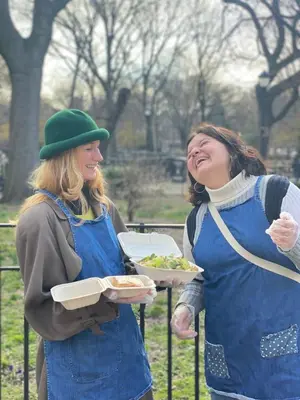 two women in aprons holding food in a park at New York Spirit Retreats HOSTEL in New York