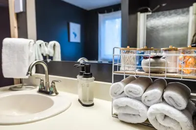 a bathroom with a sink and towels on a counter at Wine Moose w Hot tub Fireplace Sauna 9min to Mt Snow in Dover