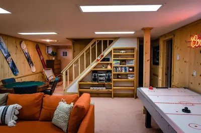 a living room with a ping pong table and a staircase at Wine Moose w Hot tub Fireplace Sauna 9min to Mt Snow in Dover