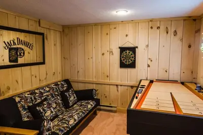 a room with a couch and a clock on the wall at Wine Moose w Hot tub Fireplace Sauna 9min to Mt Snow in Dover