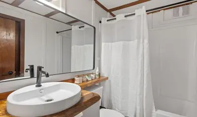 a white bathroom with a sink and a mirror at Maple Pine w Hot Tub Pool Table 3min to Mount Snow in Dover