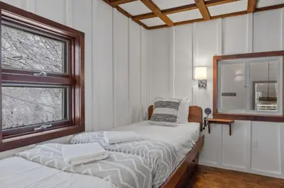 two beds in a room with two windows at Maple Pine w Hot Tub Pool Table 3min to Mount Snow in Dover