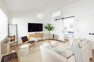 a white living room with a white couch and a tv at DUNE Fairfield Beach in Fairfield