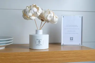 a white vase with a flower on a table at DUNE Fairfield Beach in Fairfield