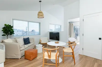 a living room with a couch and a table and chairs at DUNE Fairfield Beach in Fairfield