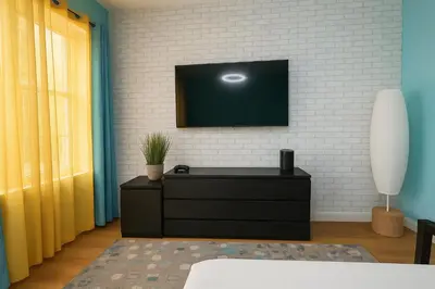 a living room with a tv on a white brick wall at Blue style Room in Guesthouse in New York
