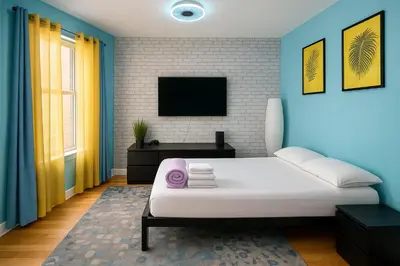 a bedroom with a white bed and a tv at Blue style Room in Guesthouse in New York