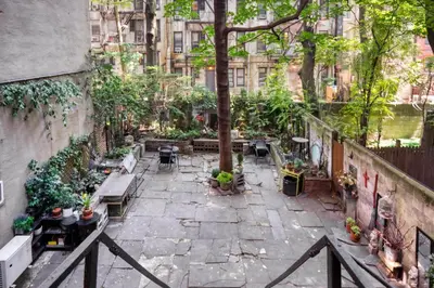 a courtyard with benches and tables and a tree at E Village Studio w renovated virtual doorman NYC-316 in New York