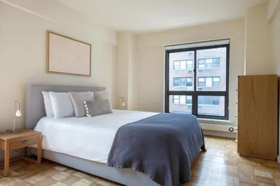 a bedroom with a large white bed and a window at Midtown E 2BR w WD nr Central Park NYC-531 in New York