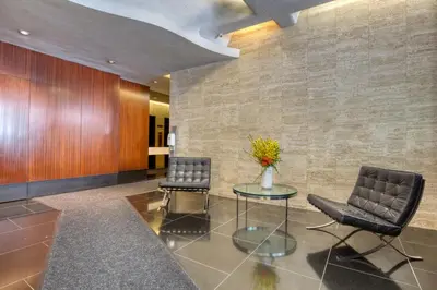 a lobby with two chairs and a table with a vase of flowers at Midtown E 2BR w WD nr Central Park NYC-531 in New York