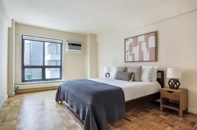 a bedroom with a large bed and a window at Midtown E 2BR w WD nr Central Park NYC-531 in New York