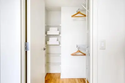 a closet with white walls and a door with shelves at LIC 1BR w WD Elevator Doorman nr E River NYC-852 in New York