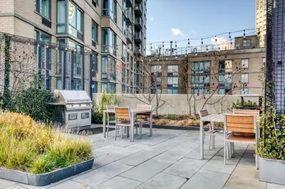 a patio with tables and chairs and a grill at LIC 1BR w WD Elevator Doorman nr E River NYC-852 in New York