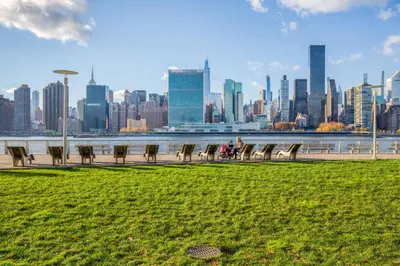 a group of benches in a park with a view of a city at LIC 1BR w WD Elevator Doorman nr E River NYC-852 in New York