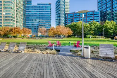 a group of chairs sitting on a boardwalk in a park at LIC 1BR w WD Elevator Doorman nr E River NYC-852 in New York