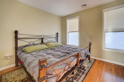 a bedroom with a bed in a room with two windows at Canal-Front Waterford Apartment on Hudson River in Waterford