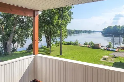 an empty porch with a view of the water at Canal-Front Waterford Apartment on Hudson River in Waterford