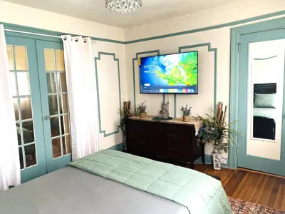 a bedroom with a bed and a flat screen tv at NYC Cozy Private Bedroom with Free Parking & Near Subway - Business & Tourists in Van Nest