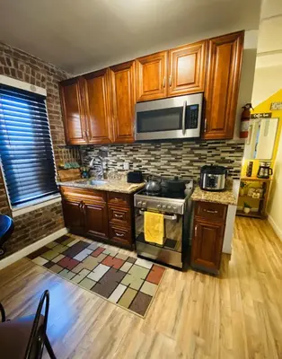 a kitchen with a stove and a microwave at NYC Cozy Private Bedroom with Free Parking & Near Subway - Business & Tourists in Van Nest