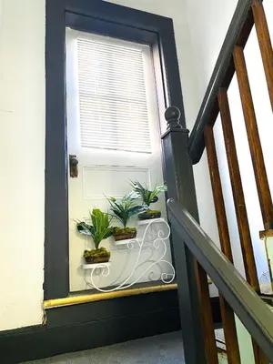 a window with potted plants on a table next to a staircase at NYC Cozy Private Bedroom with Free Parking & Near Subway - Business & Tourists in Van Nest