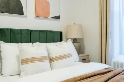 a bed with white pillows and a green headboard at 74-4A 2BR 2baths in Prime Upper West Side w d GYM in New York