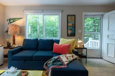 a living room with a blue couch and windows at Hot Cocoa Bar 4 Season Porch wWood Stove in Pocono Country Place