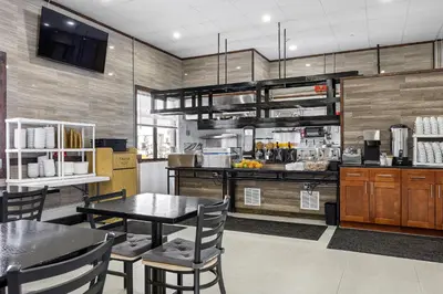 a dining room with a table and a kitchen at Highbridge Hotel in Bronx