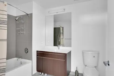 a bathroom with a sink and a toilet and a mirror at Hoboken 2BR w PATH Shuttle Gym WD NYC-813 in Hoboken