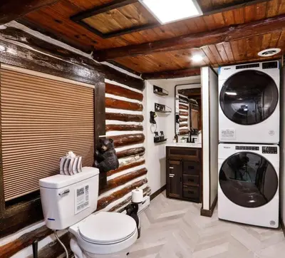 a bathroom with a toilet and a washer and dryer at Poconos Pool Paradise in East Stroudsburg