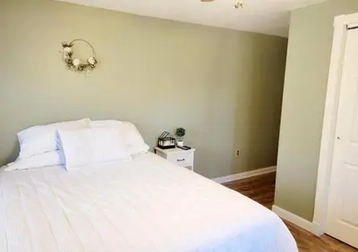 a bedroom with a white bed with a wreath on the wall at The Family Getaway in Tobyhanna