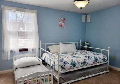 a bedroom with blue walls and a bed and a window at The Family Getaway in Tobyhanna