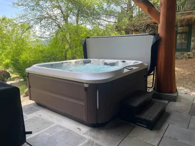 a hot tub sitting on top of a patio at Cayuga Lodge South in Cooperstown