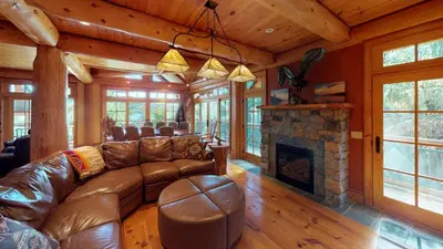 a living room with a couch and a fireplace at Cayuga Lodge South in Cooperstown
