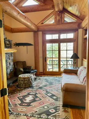 a living room with a couch and a fireplace at Cayuga Lodge South in Cooperstown