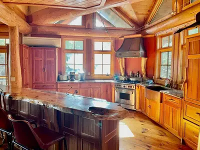 a large kitchen with wooden cabinets and a large island at Cayuga Lodge South in Cooperstown