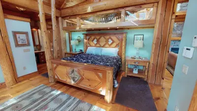 a bedroom with a bed in a room with wooden floors at Cayuga Lodge South in Cooperstown