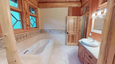 a large bathroom with a tub and a sink at Oneida Lodge North in Cooperstown
