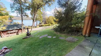 a backyard with a grill in the grass at Oneida Lodge North in Cooperstown