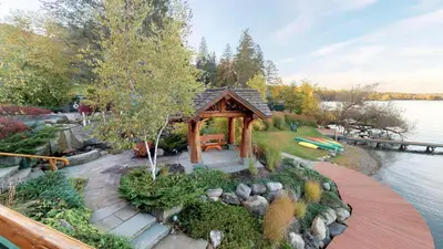 a gazebo in a garden next to a lake at Oneida Lodge North in Cooperstown
