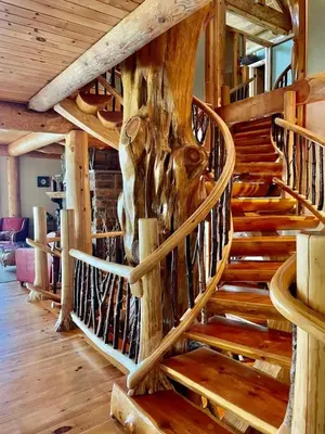 a wooden spiral staircase in a log cabin at Oneida Lodge North in Cooperstown