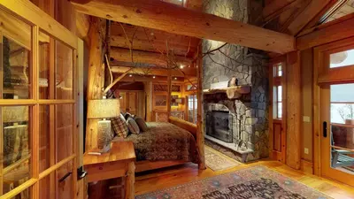 a bedroom with a bed and a stone fireplace at Seneca Lodge in Cooperstown