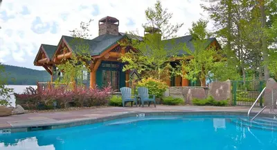 a house with a swimming pool in front of a house at Seneca Lodge in Cooperstown