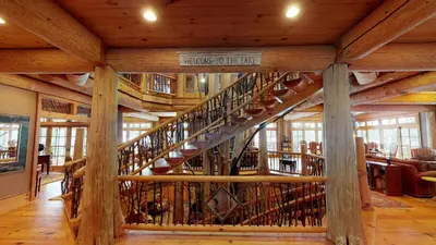a large wooden staircase in a building with wooden beams at Seneca Lodge in Cooperstown