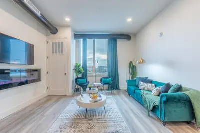 a living room with a blue couch and a table at Emerald Escape, Free Parking, 2 Bath, Sleeps 8 Near American Dream and The Airport, King Bed and 2 Queen Beds, Washer and Dryer in Orange