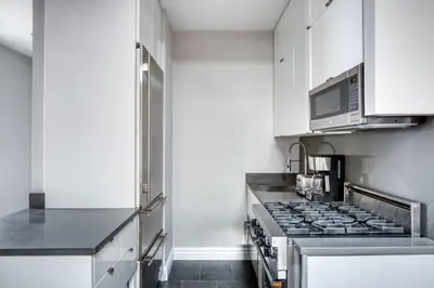 a kitchen with a stove and a microwave at UES 3br penthouse w wd nr Central Park NYC-1110 in New York